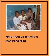 A visiting woman sitting indoors with a Kenyan mother and her children