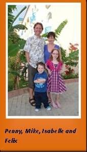 A family of two adults and two young children standing together in a garden