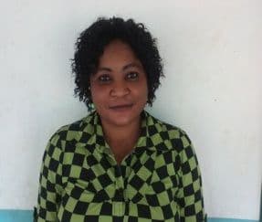 Head-and-shoulders portrait of a woman in a green and black checked top