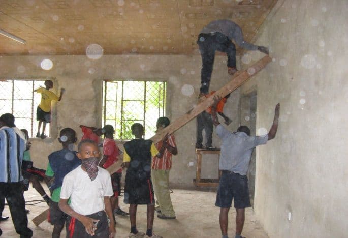 Pupils and workers on ladders painting the walls inside the new library