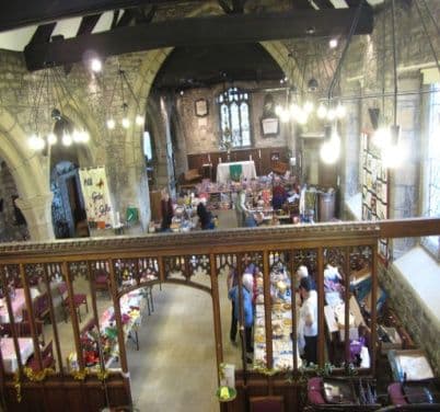 View from a gallery over the fayre stalls set out in a stone church hall