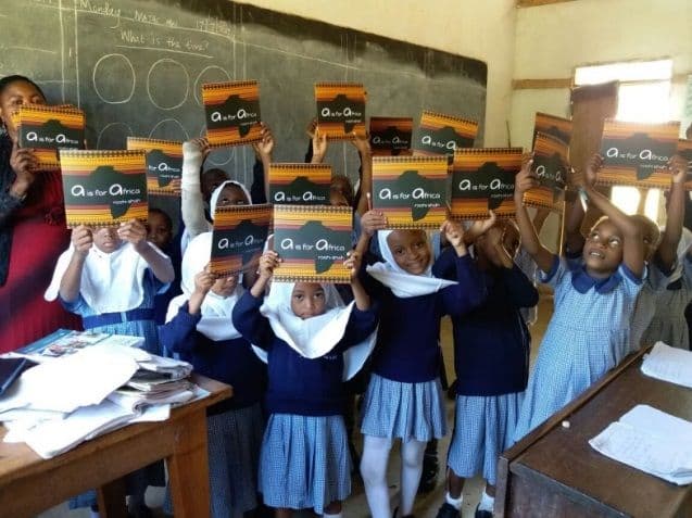Pupils in a classroom holding up copies of the same new picture book