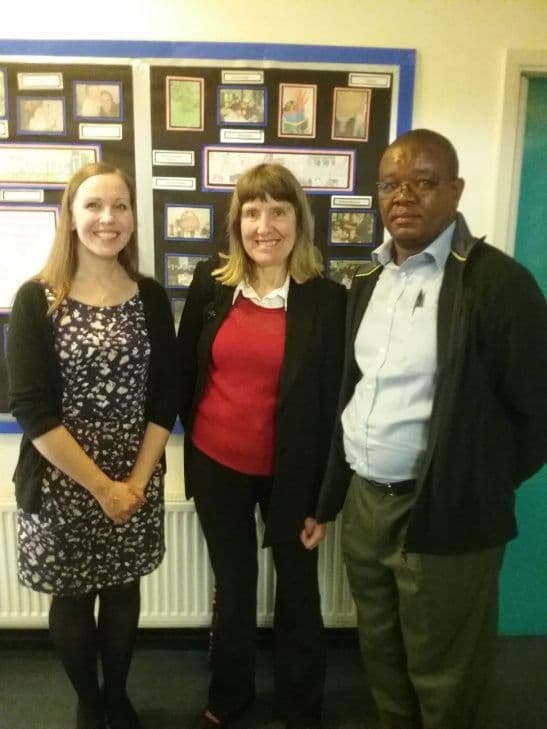 A younger woman, an older woman and a man standing together in a UK classroom