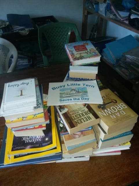Stacks of donated children’s books piled on a table