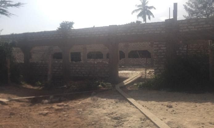 Unfinished block-walled building with open window gaps under construction