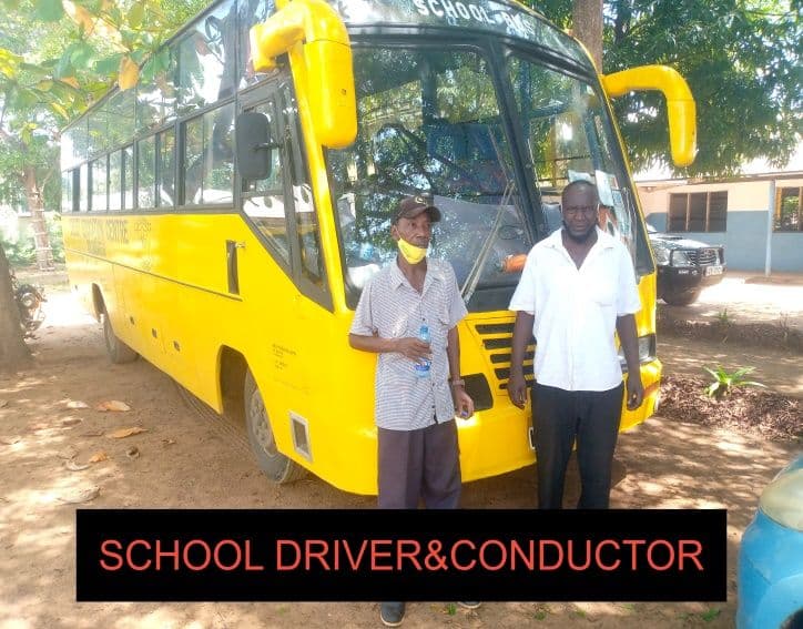 Two men standing in front of a yellow school bus