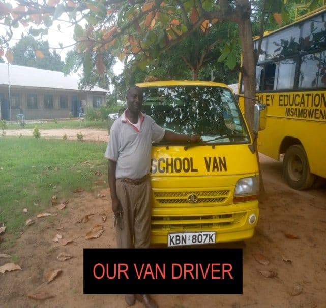 A man leaning on a yellow school van parked beside a school bus