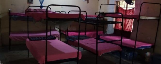 Dormitory with metal bunk beds and pink mattresses
