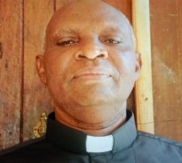 Head-and-shoulders portrait of a man wearing a black clerical shirt and white collar