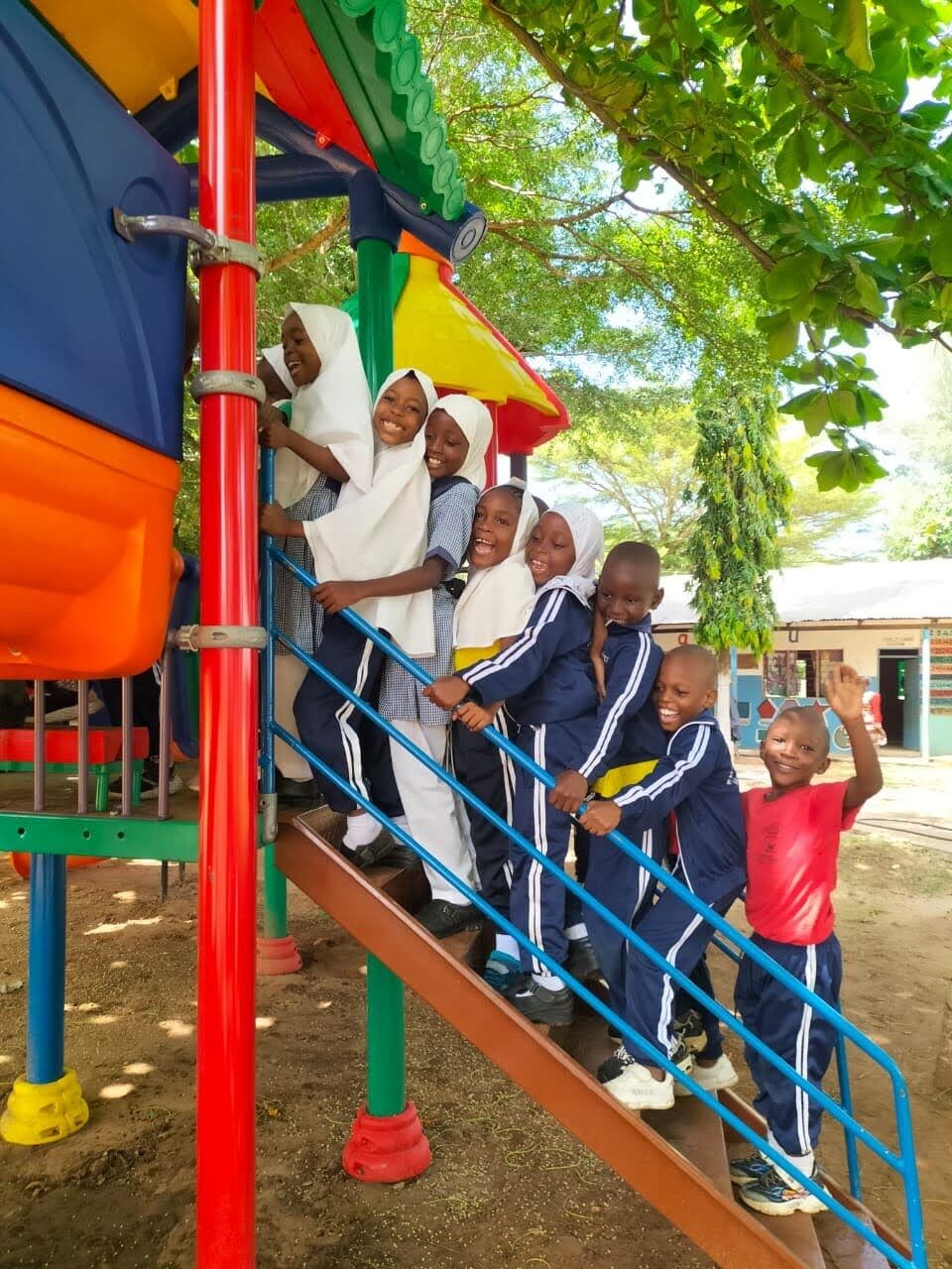 Primary learners on the playground climbing frame