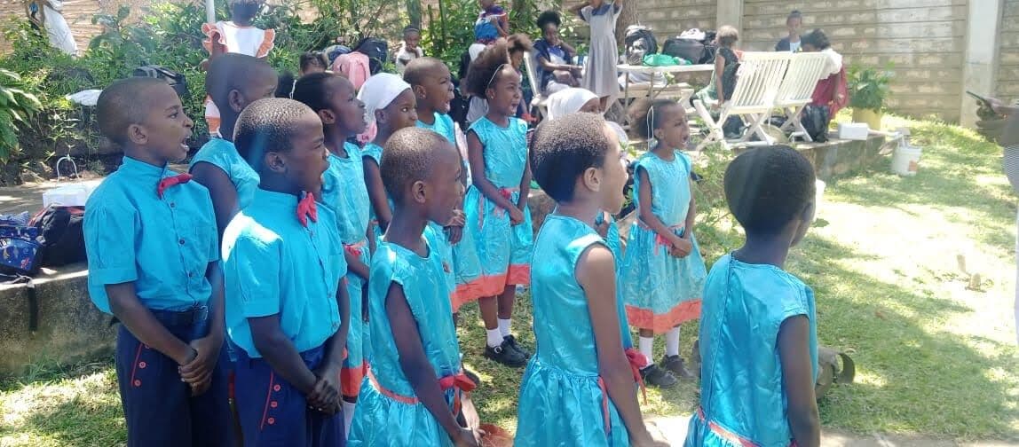 Pre-primary learners in blue uniforms outdoors