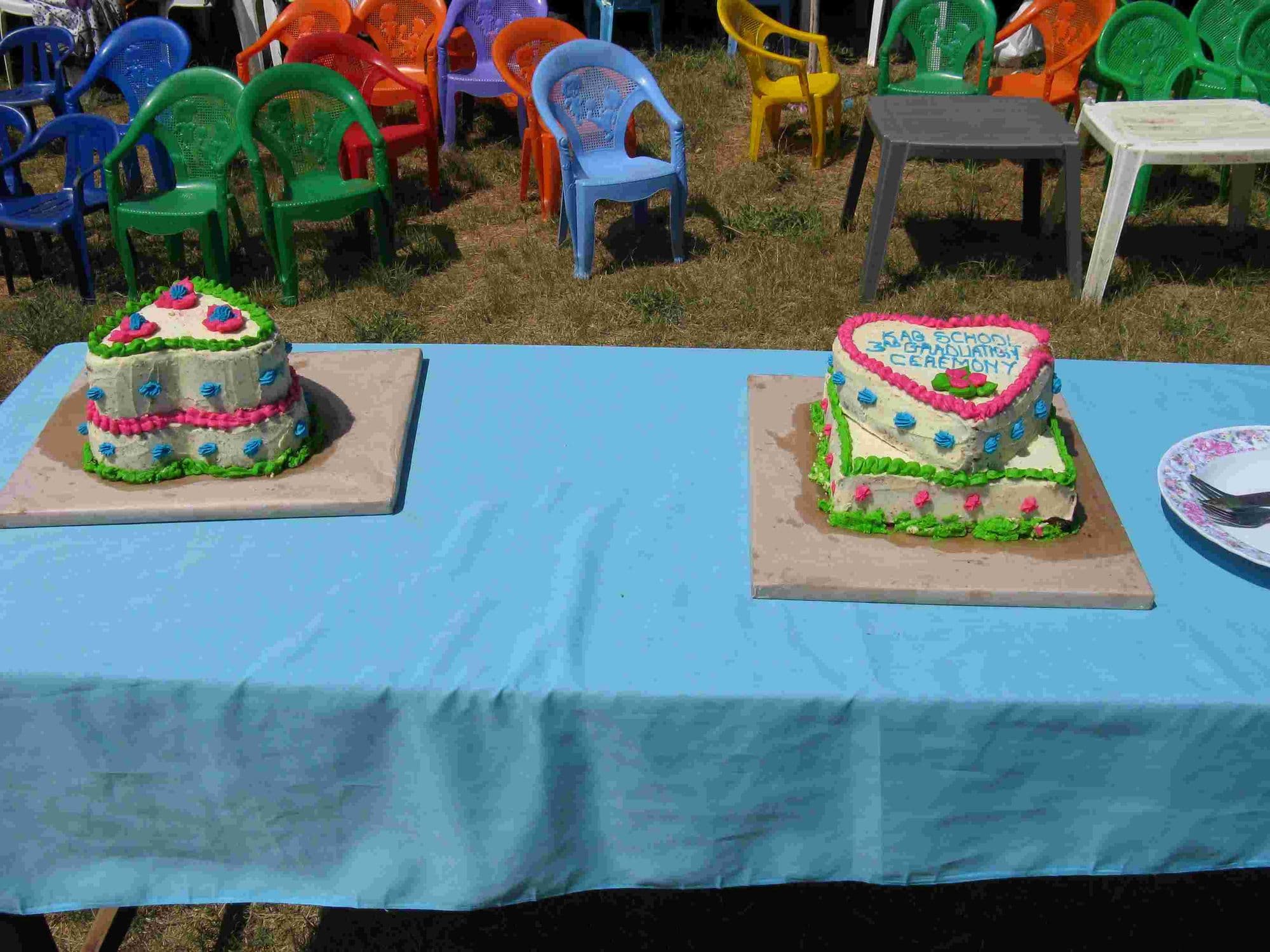 Two iced graduation cakes on a table with a blue cloth