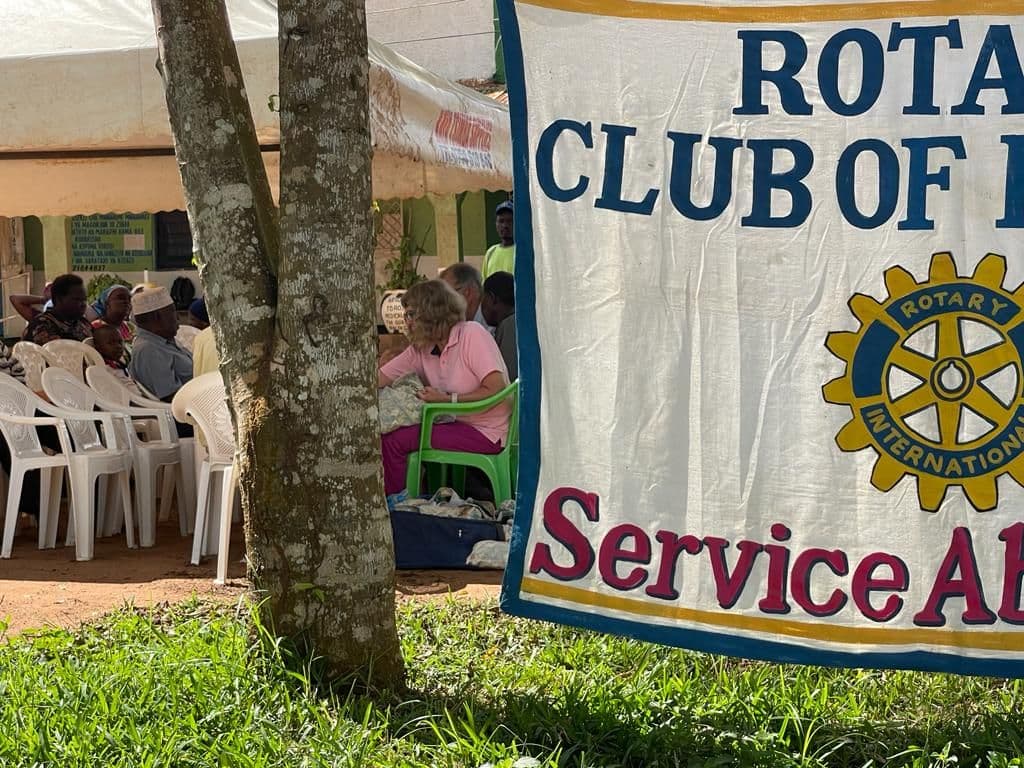 A Rotary Club banner hanging beside the tent where people wait for eye tests