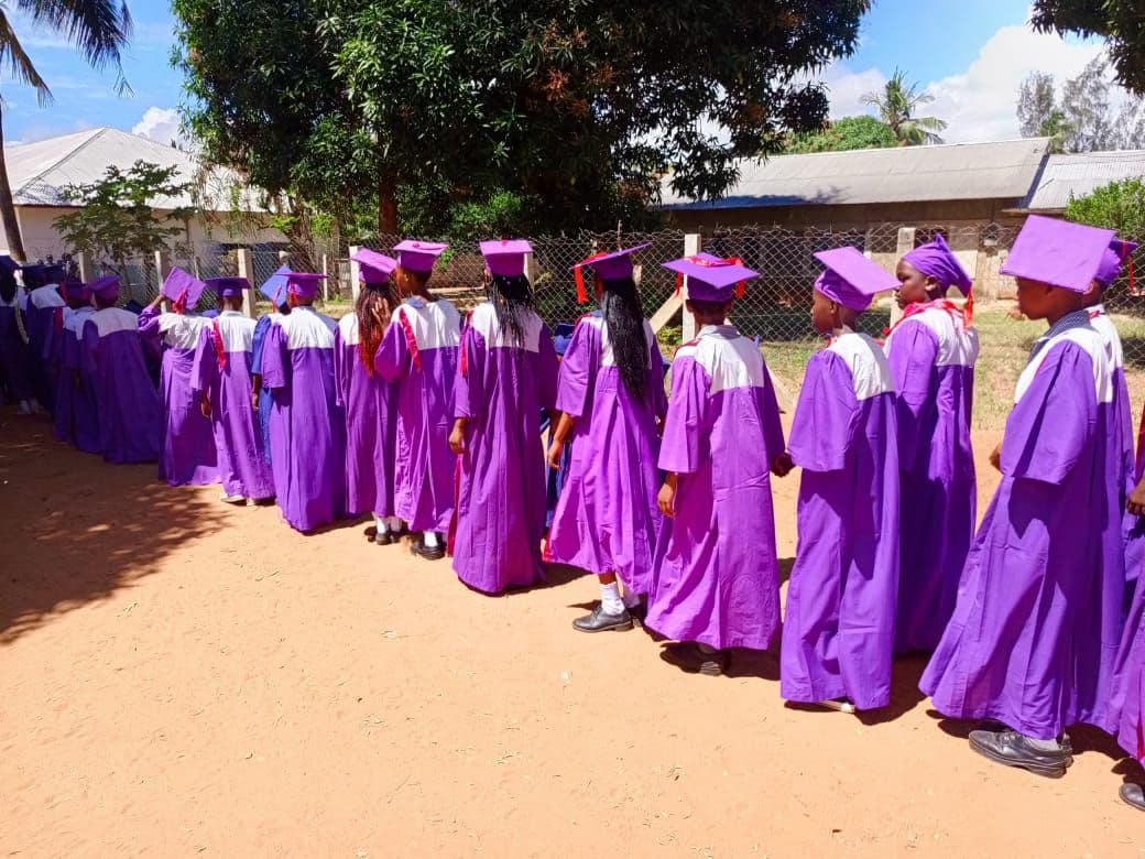 Children in purple graduation gowns and caps walking in a line