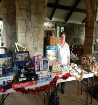 A woman at a stall of jigsaw puzzles and bric-a-brac