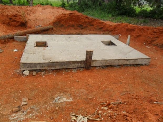 A new concrete septic tank slab set in red earth