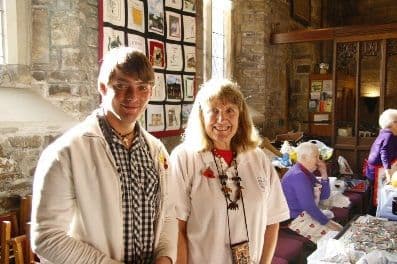 Young man and woman standing together at the sale in the church hall