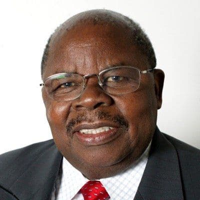 Portrait of an older man with glasses in a dark suit and red tie