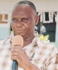 Man in a checked shirt speaking into a microphone