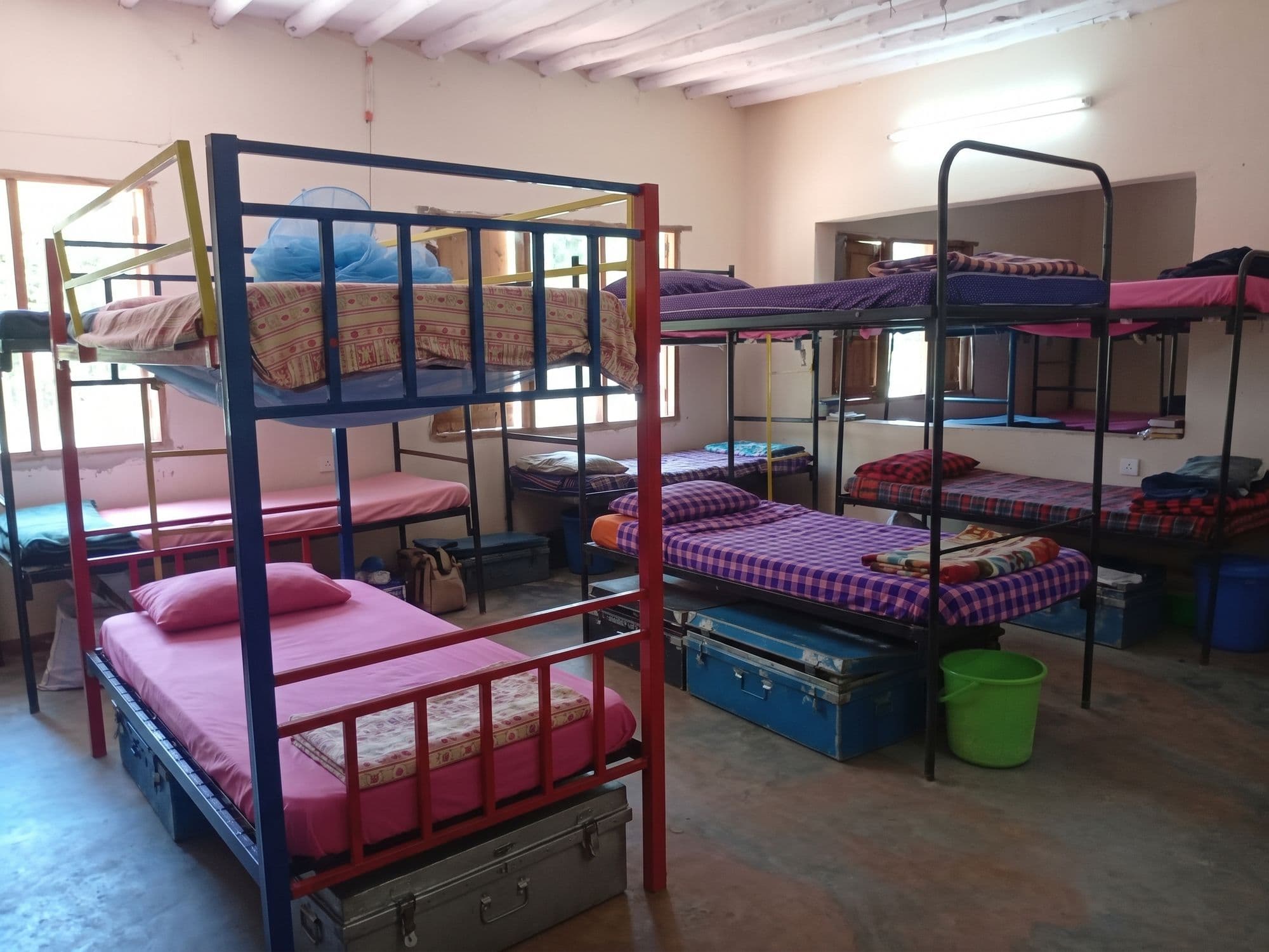 Bunk beds made up with checked blankets in the boys’ dormitory