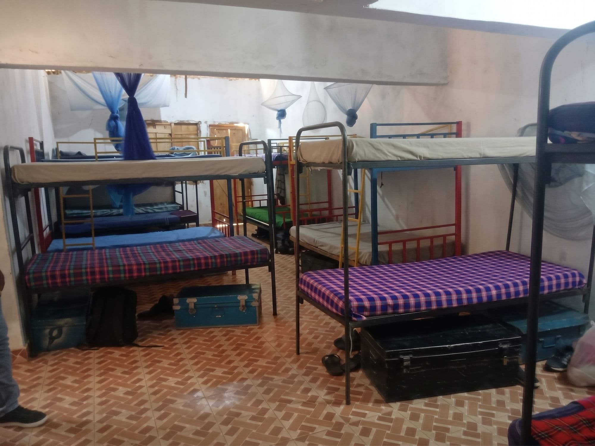 Bunk beds with mosquito nets and boxes in the girls’ dormitory