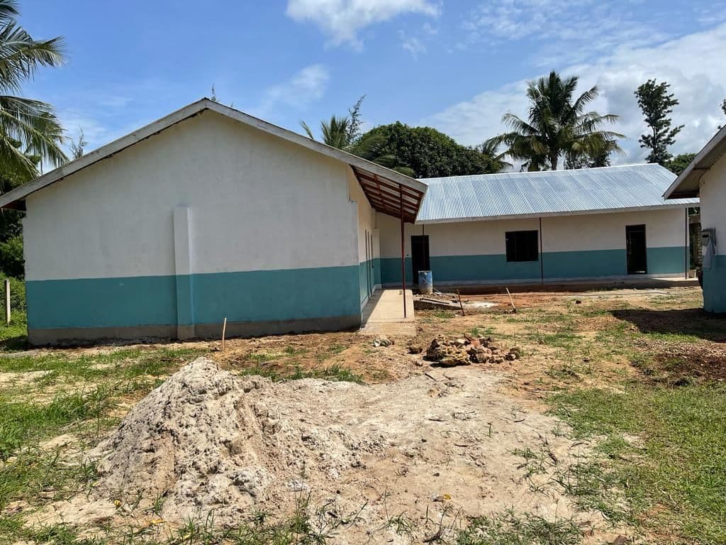 New white and teal lab buildings with a pile of building stone in front