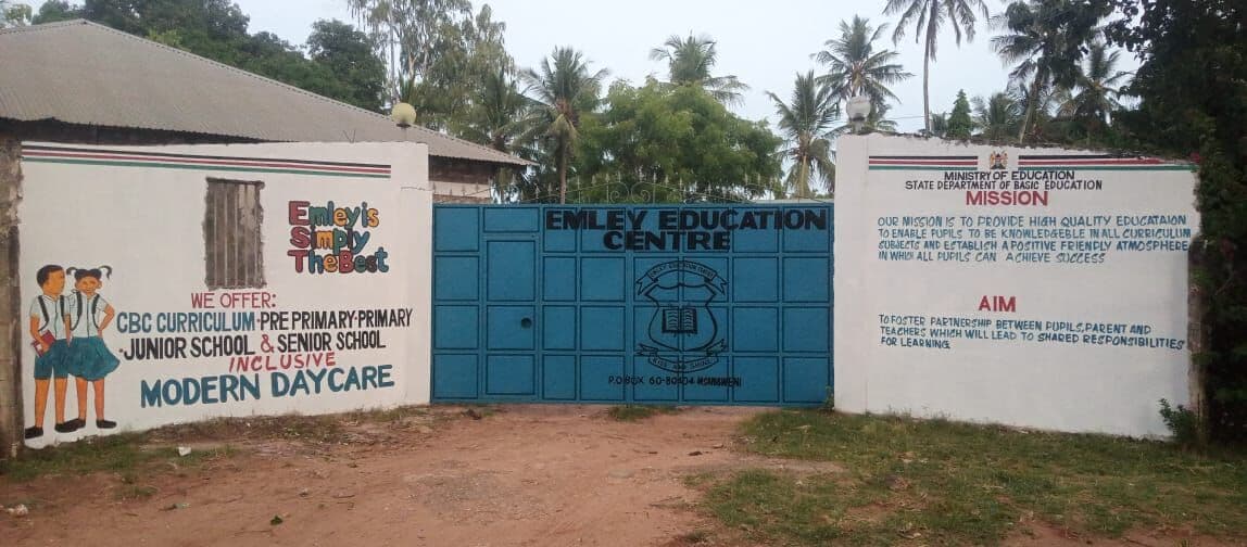 The blue gates of Emley Education Centre, with the school mission and aim painted on the walls
