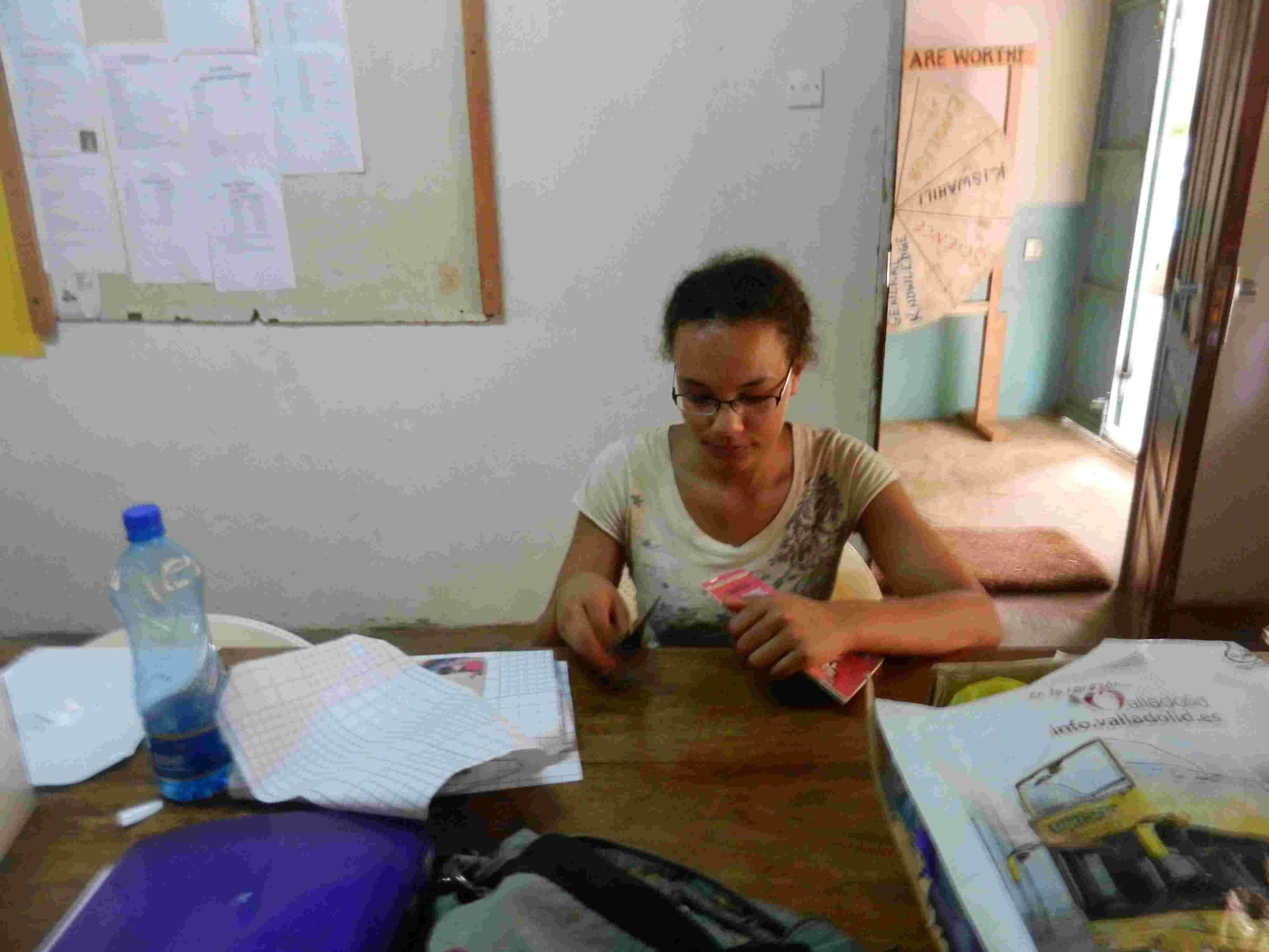 A young UK student on placement sitting at a desk with craft materials