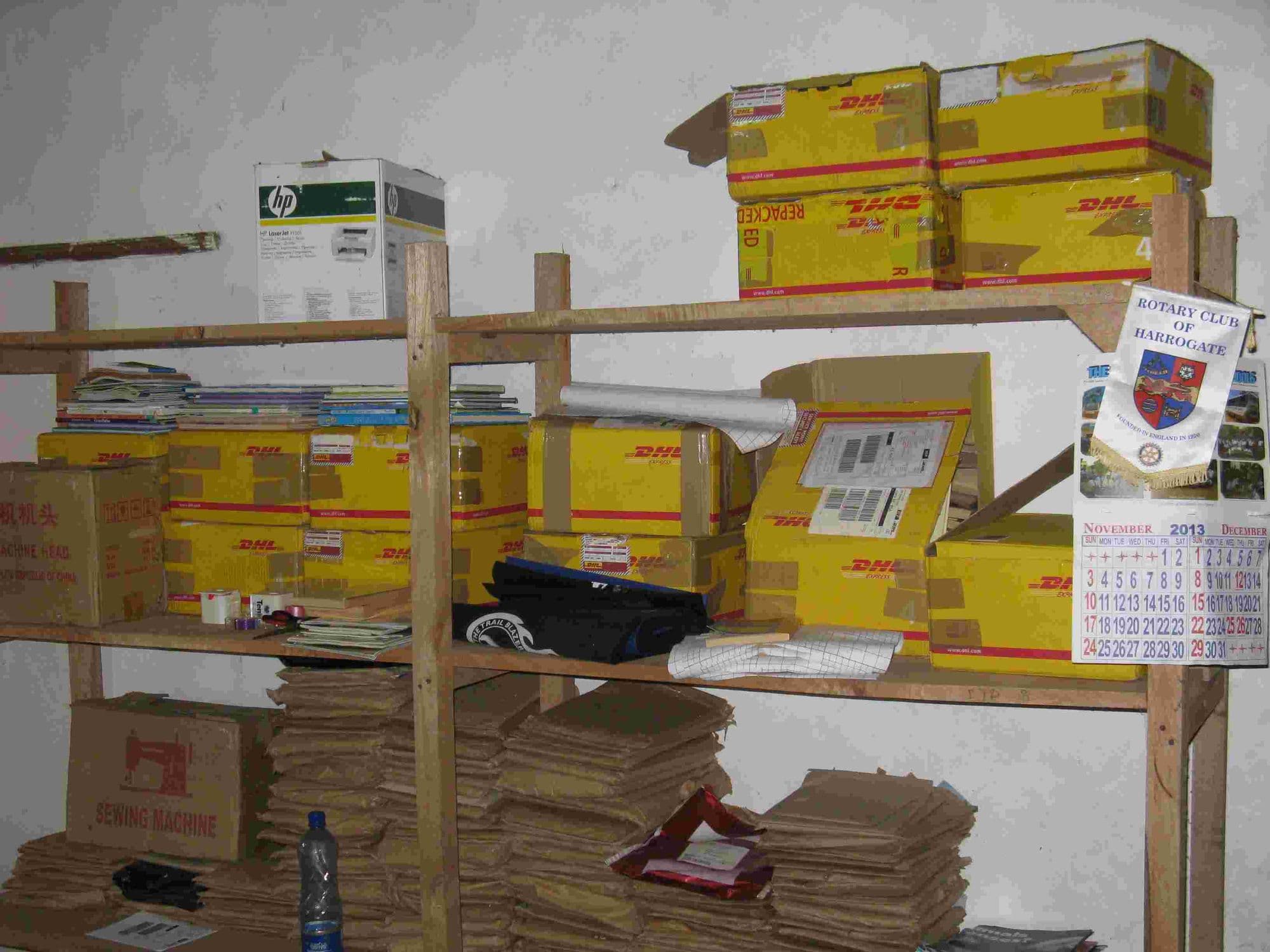 Shelves stacked with DHL boxes of donated books and brown paper bags