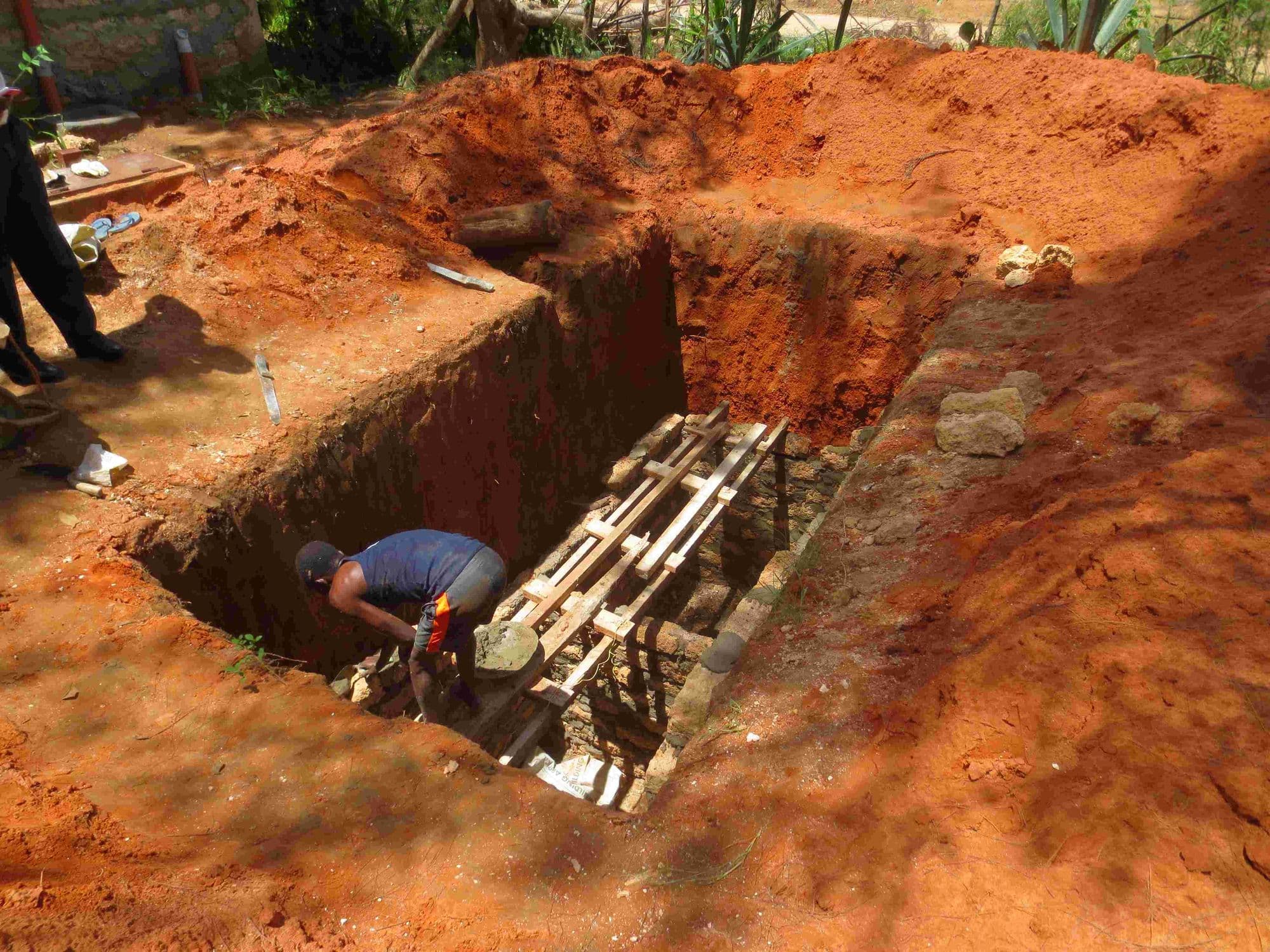 A worker inside a deep pit dug for a septic tank