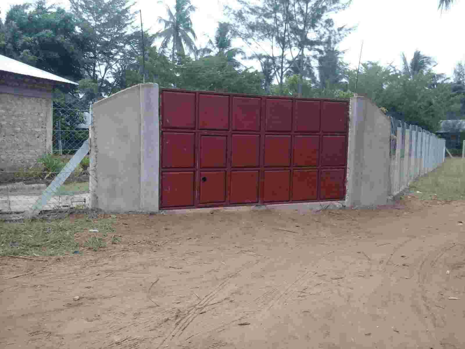 A new red metal gate set in a concrete wall at the school entrance