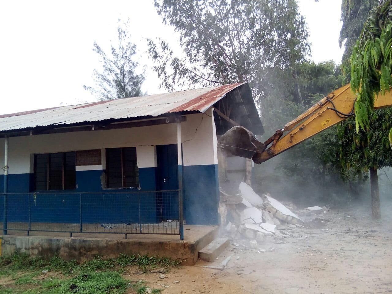 A bulldozer demolishing the nursery classroom nearest the road