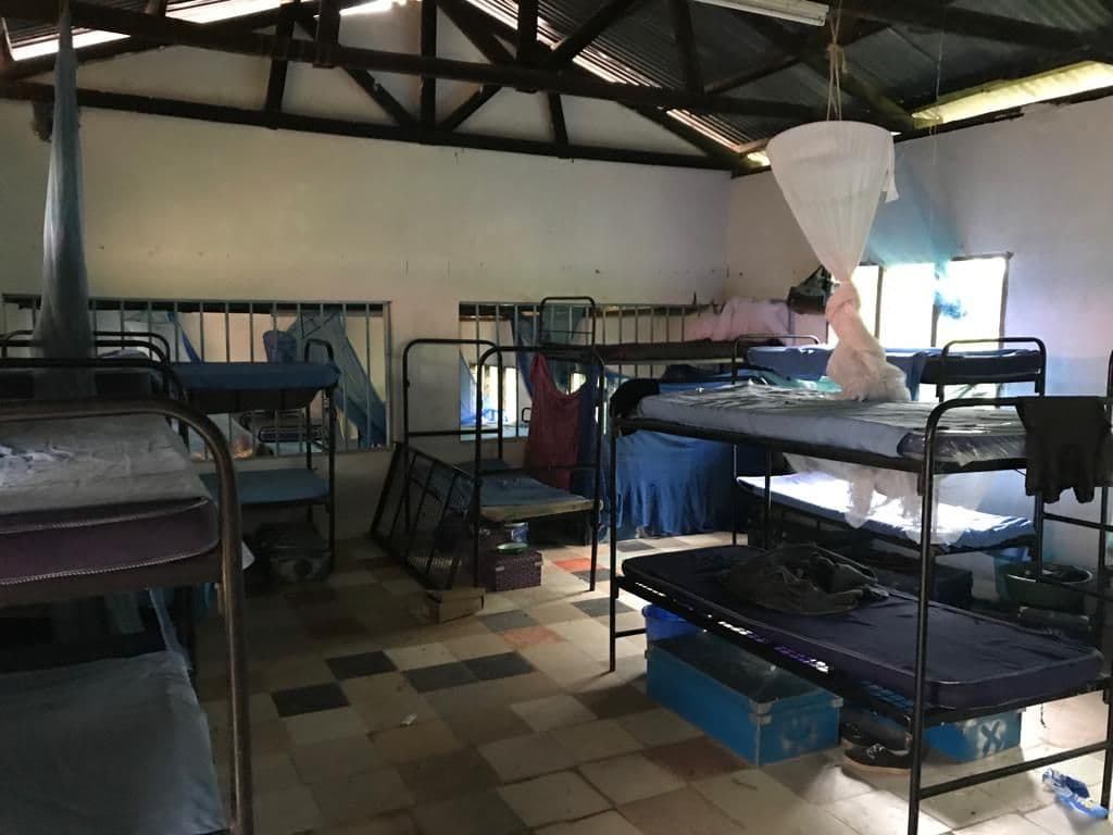 Bunk beds with mattresses and mosquito nets in the converted boarding room