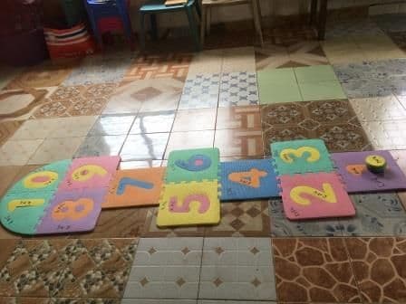 A foam number hopscotch mat on the tiled nursery classroom floor