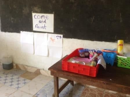 A painting station on a table below a sign reading come and paint