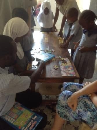 Young pupils doing jigsaws and games at a table