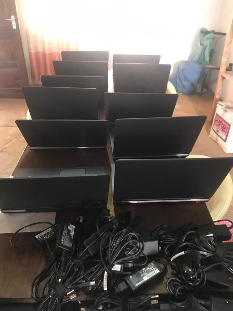New laptops stacked on a table with their chargers