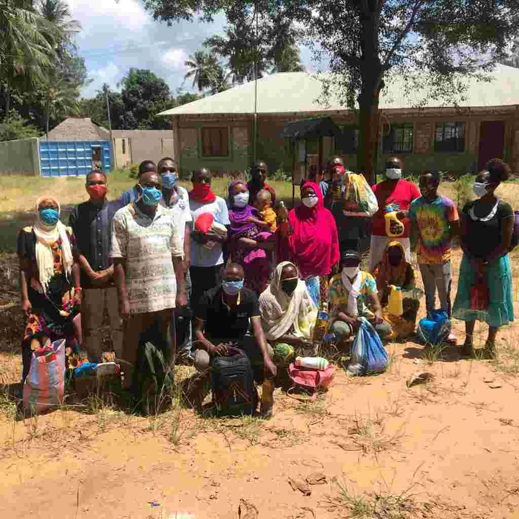 Parents and children wearing face masks gathered outside to collect food
