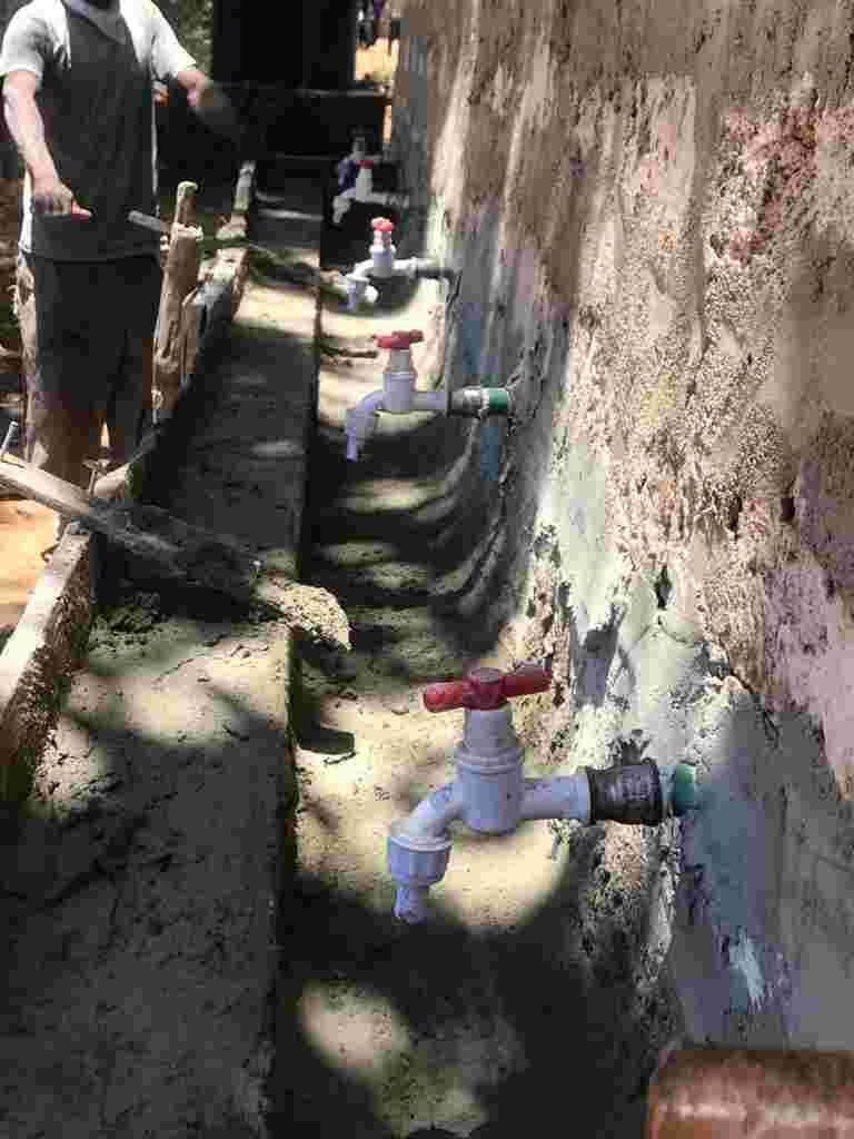 A row of new taps fitted along a wall for handwashing