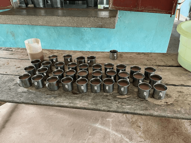 Rows of metal cups of porridge laid out on a table