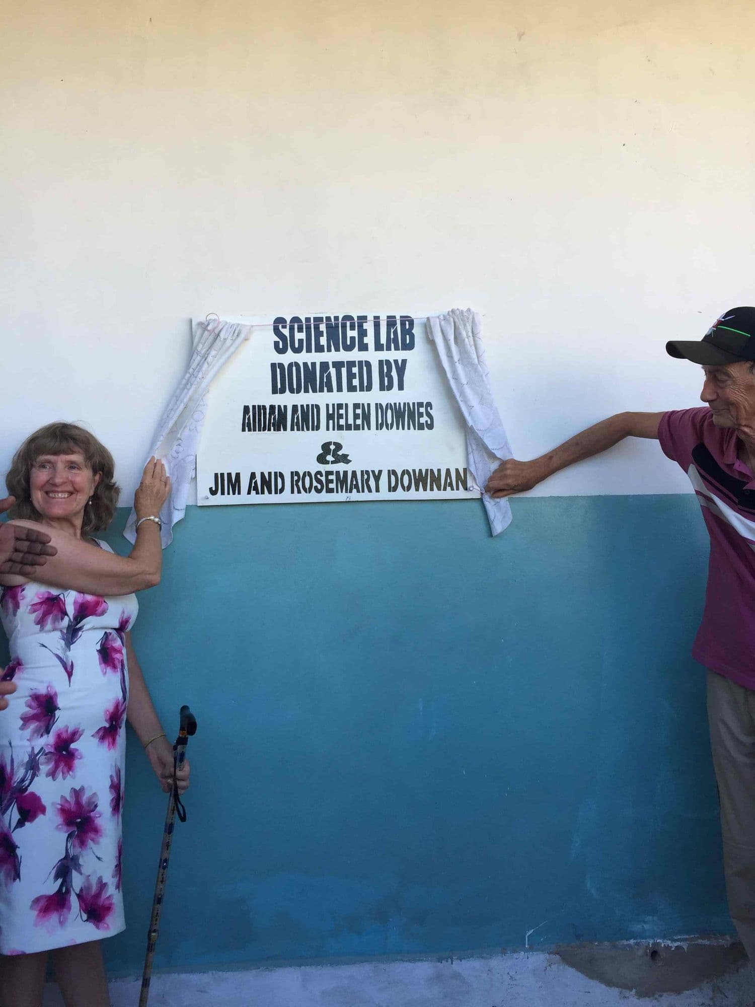 Two visitors unveiling the plaque for the science lab donated by Aidan and Helen Downes and Jim and Rosemary Downan