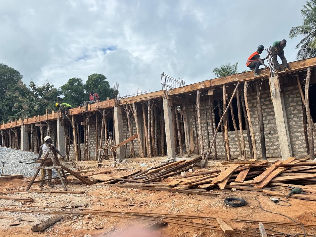 Builders working on top of the propped formwork along the new classroom block