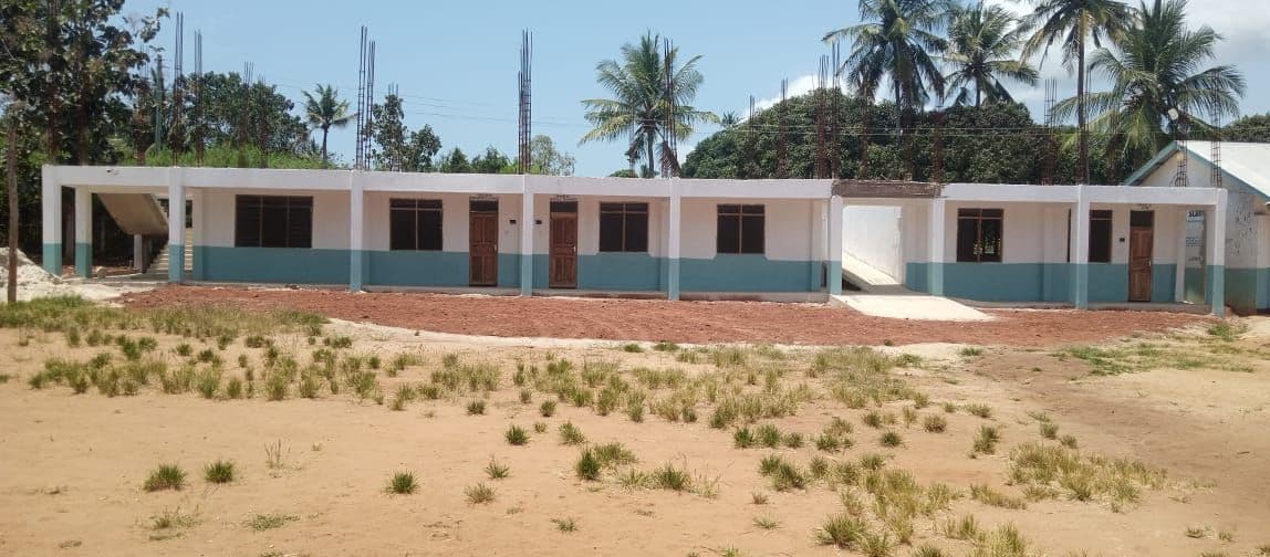 The finished row of new secondary classrooms across open sandy ground
