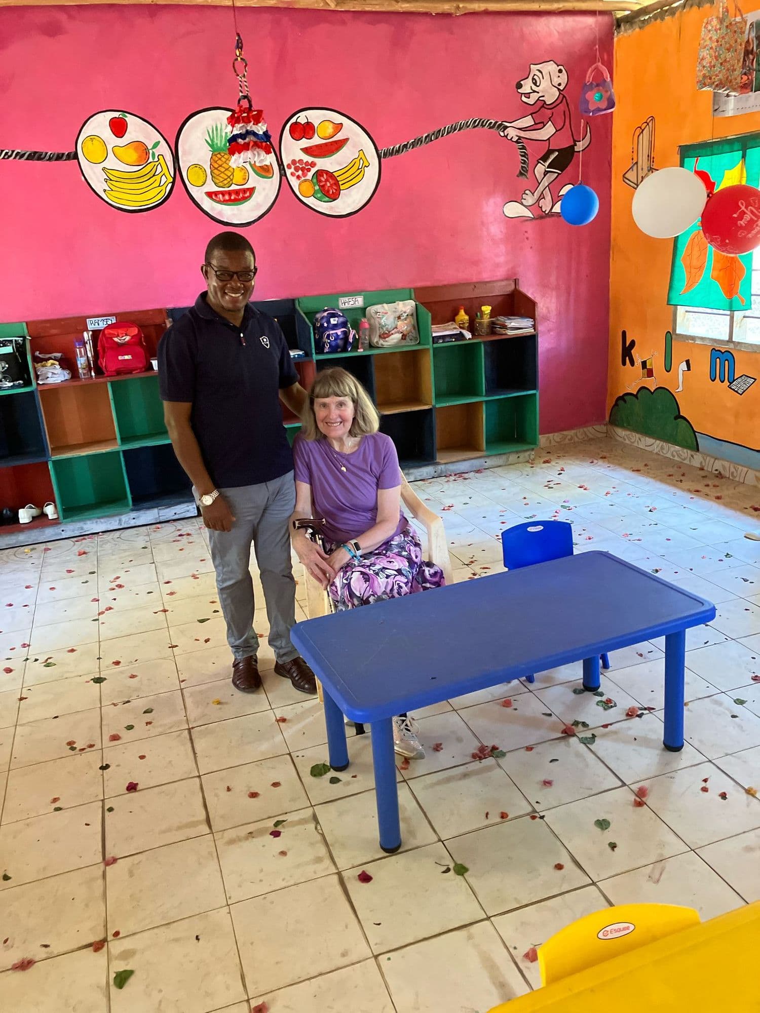A visitor and the headmaster standing in the painted baby classroom