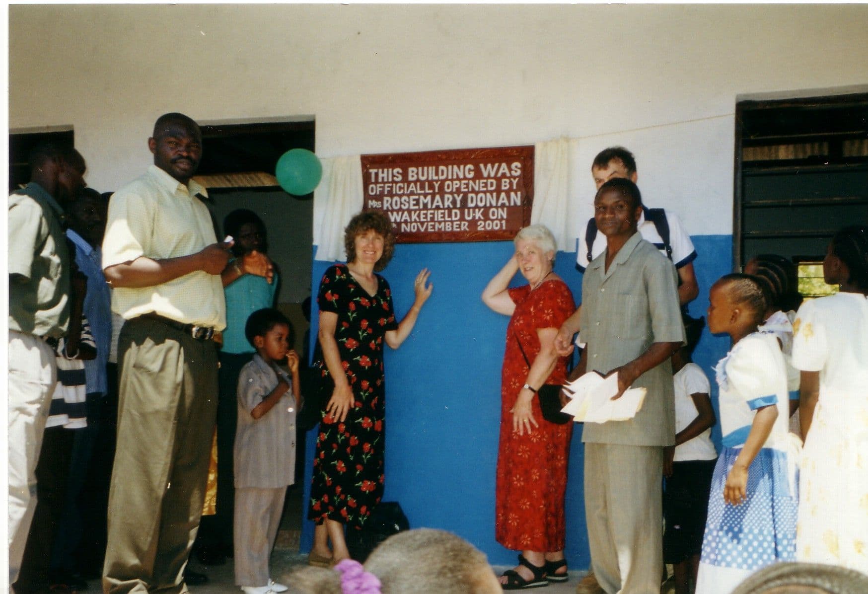 Visitors and local guests gathered at a plaque on the new nursery school wall for the opening