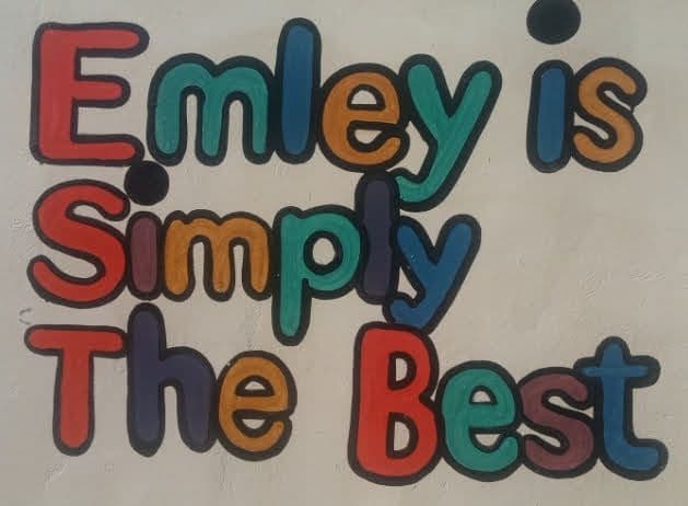 Colourful painted letters on a wall reading Emley is Simply The Best
