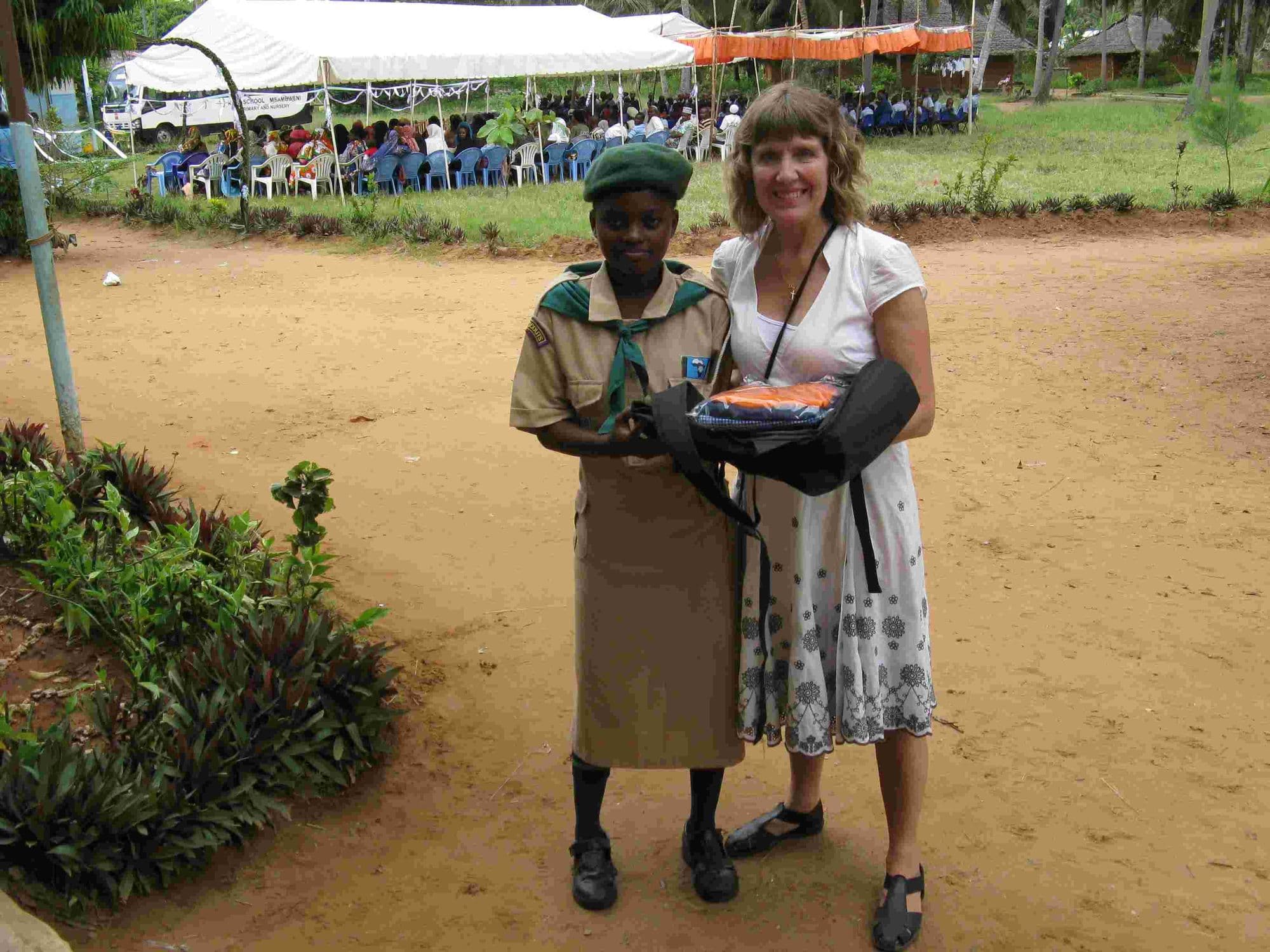 A visitor presenting a uniformed scout with a gift at the graduation ground