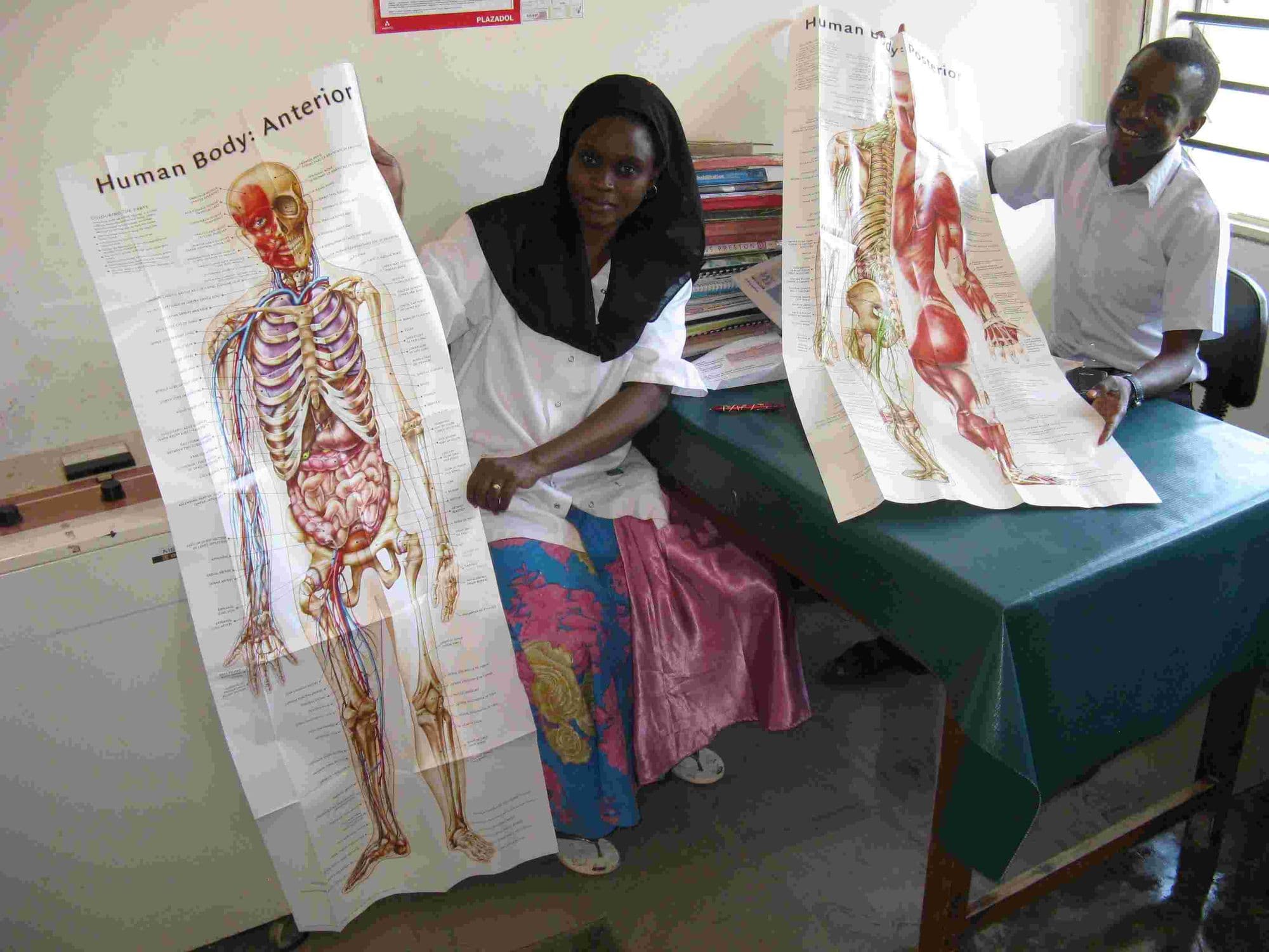 Two hospital staff holding up donated human anatomy charts